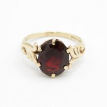 9ct gold oval cut garnet dress ring with patterned shoulders (1.9g) Size L