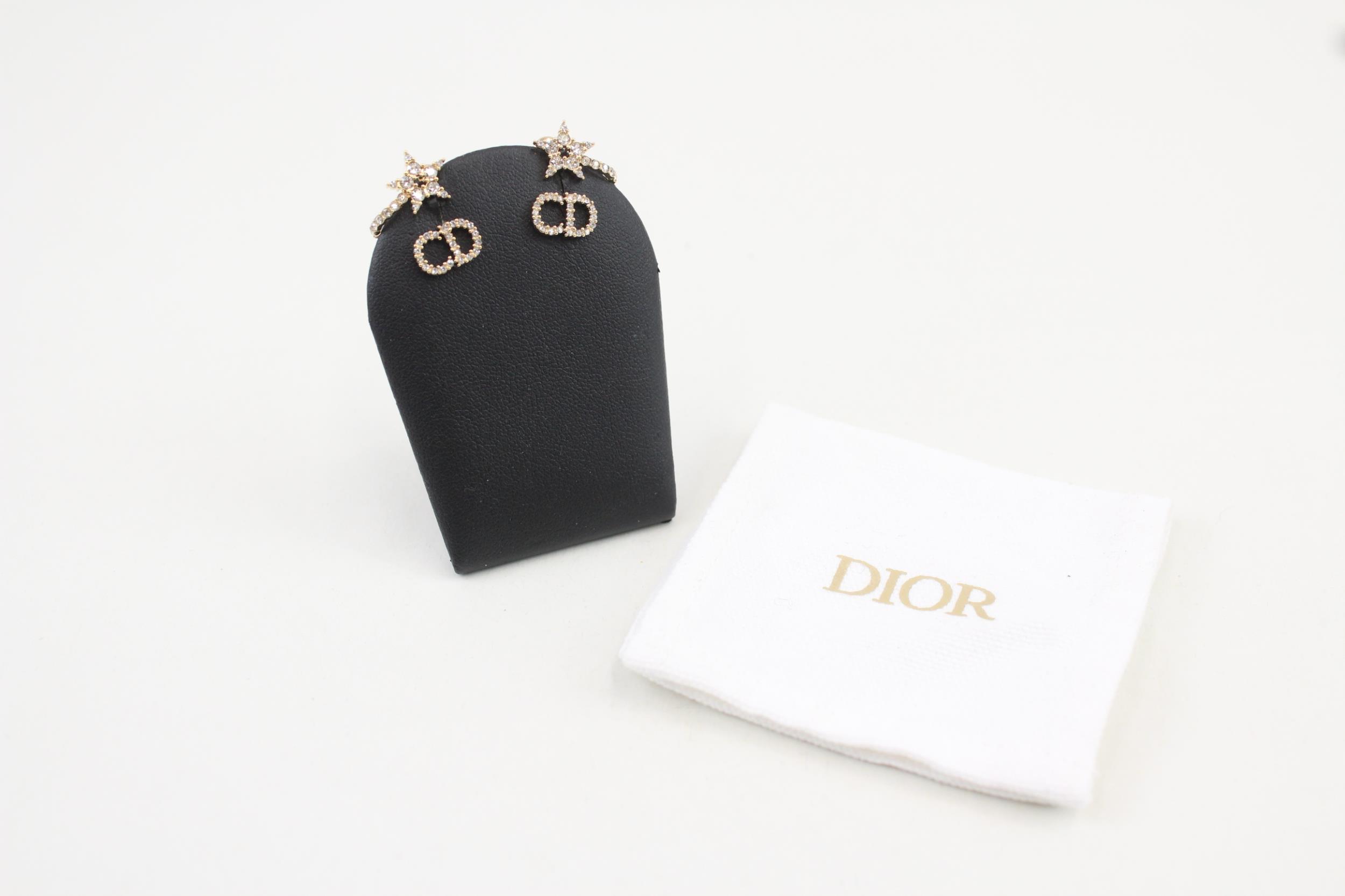 Pair of gold tone rhinestone earrings by designer Christian Dior with pouch (3g)
