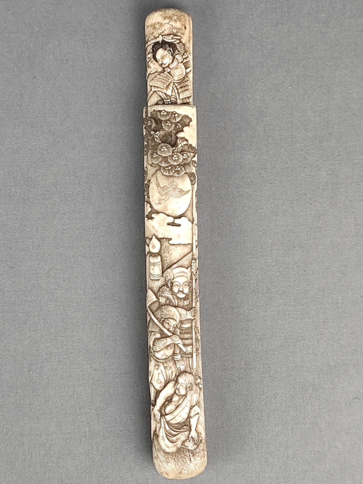 Knife sheath/case, probably Japan, with samurai depictions in relief in front of a landscape, consi