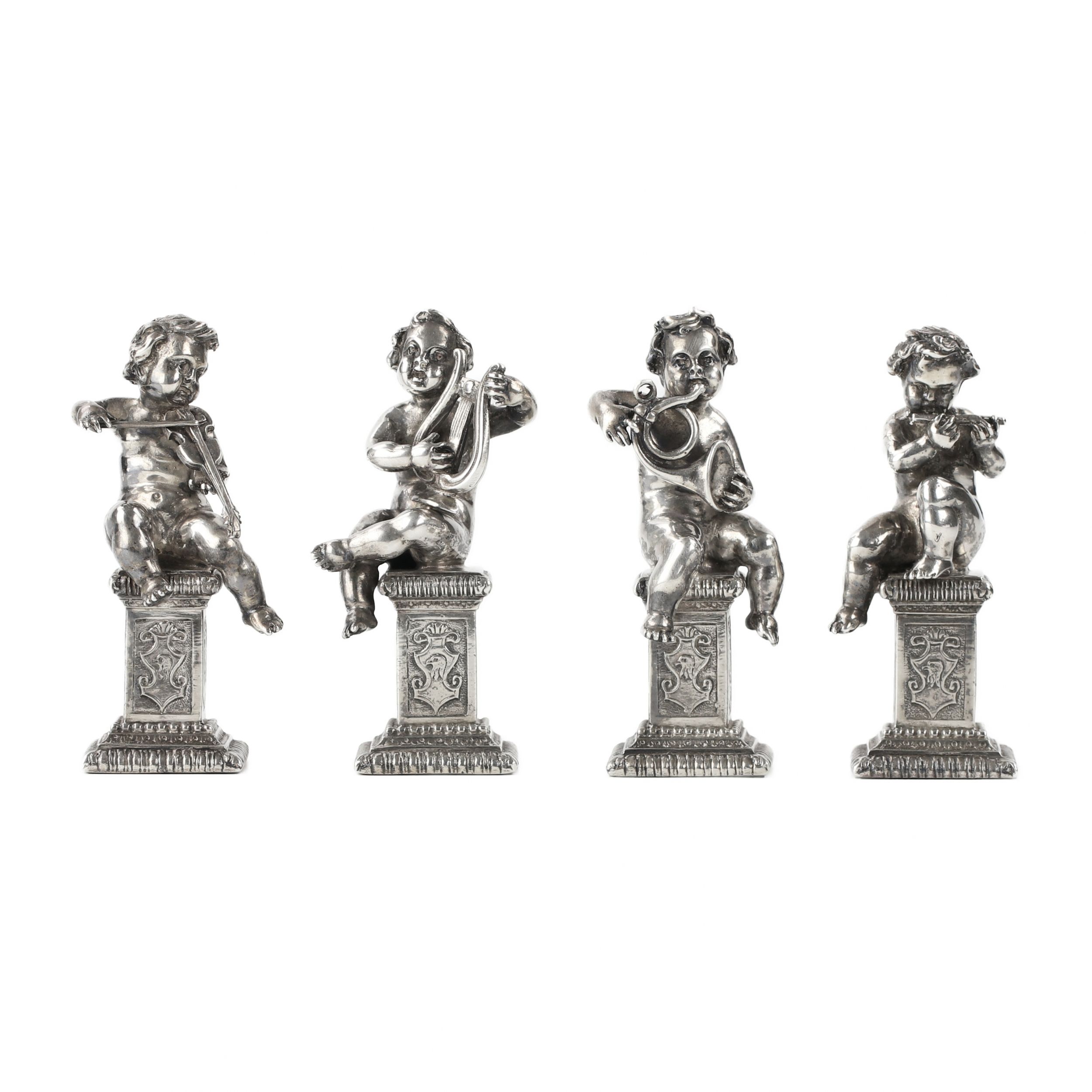 Four funny figures of putti musicians in silver.