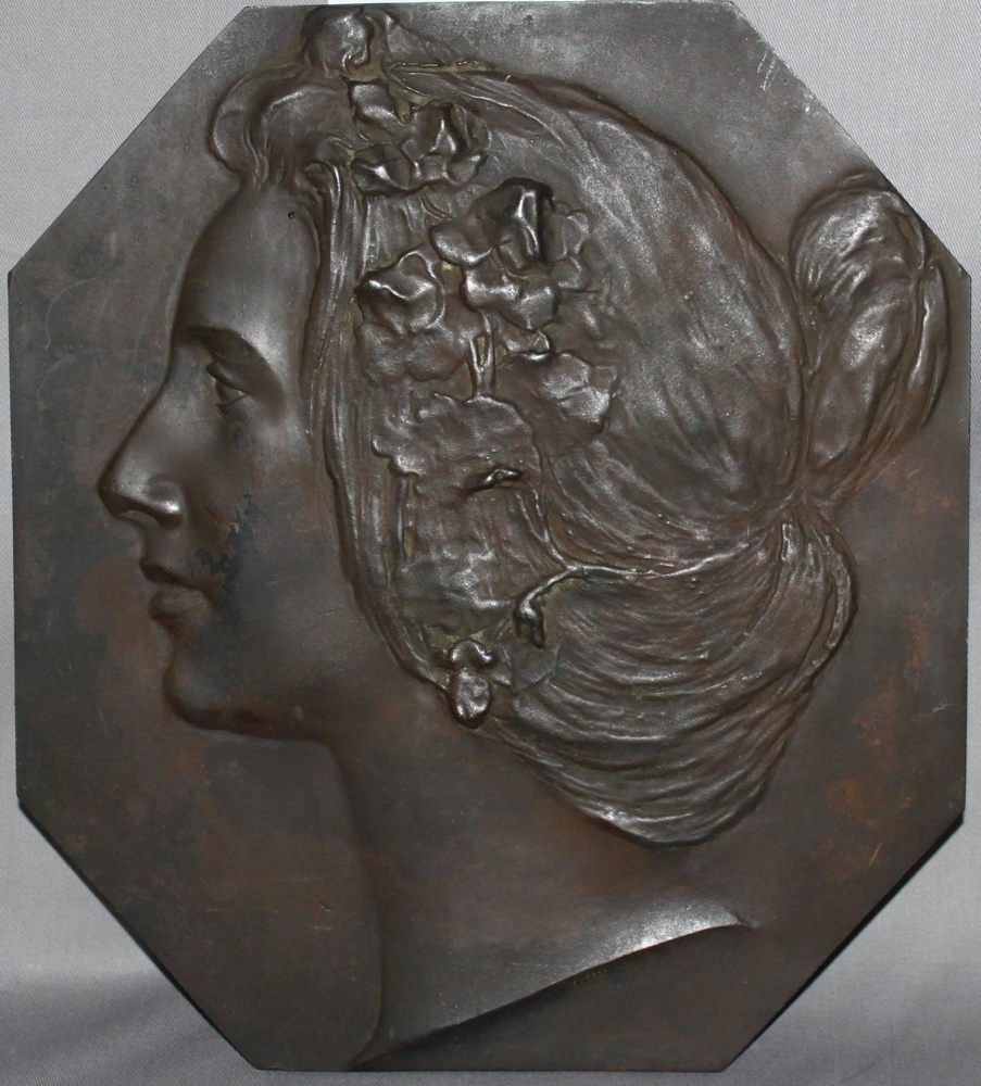 Metall. Bronzerelief. (Kopfporträt einer jungen Frau). Achteckiges Bronzerelief (dunkel