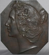 Metall. Bronzerelief. (Kopfporträt einer jungen Frau). Achteckiges Bronzerelief (dunkel