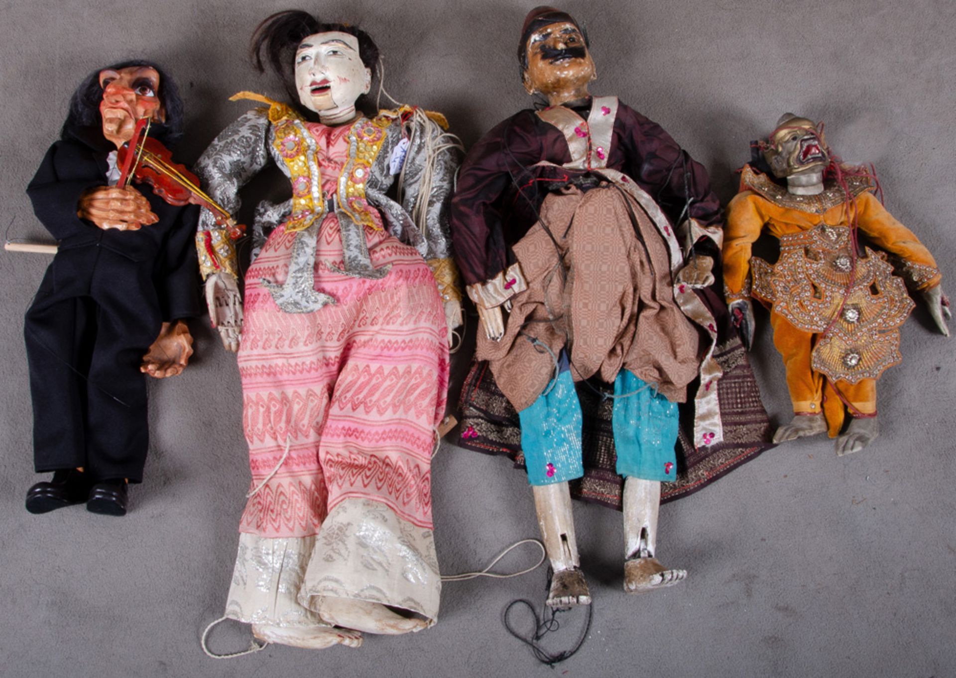 Drei Marionetten. Südostasien. Massivholz, geschnitzt, teilw. bemalt, in Samt-, Seiden- und Brokatbe