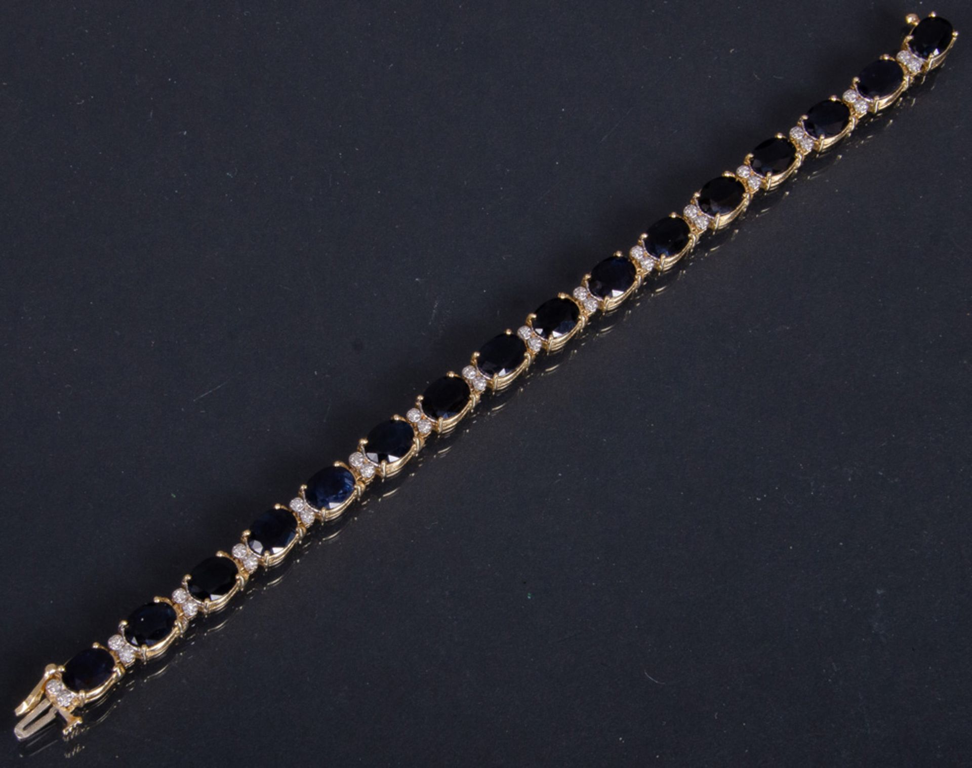 Armband, GG/WG, gestempelt 585/-, ausgefasst mit 16 sehr dunklen - fast schwarzen - ovalen