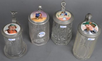Vier unterschiedliche Bierseidel. Deutsch um 1900. Farbloses Glas mit Zinndeckelmontur und Porzellan