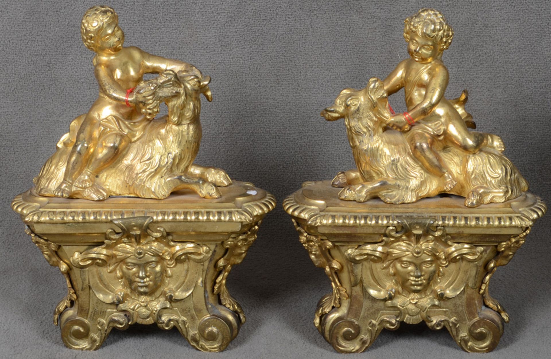 Paar Putten auf Ziegenbock. Paris 18. Jh. Bronze, feuervergoldet. Je auf ovalem, erhöhtem Sockel mit
