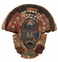 Ancient African mask, dan People, made of wood, cloth, raffia and shells, approximately 1920-1930.