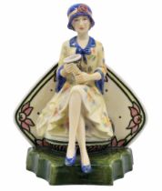 English ceramic figurine, in the shape of a woman holding a vase, designed by Andy Moss, decorated