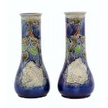 A pair of antique English ceramic vases made by 'Royal Doulton', decorated with enamel and signed.