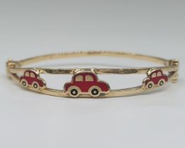 A bracelet made of yellow gold, made of 14 karat yellow gold and enamel. Decorated with red car