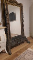 A large and impressive antique mirror (floor mirror)., made of carved wood, glass with a phase,