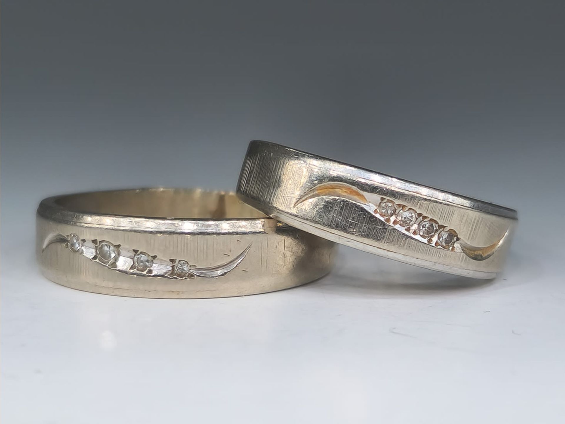 A set of 2 gold rings made of 14K white gold with small diamonds, with a total weight of