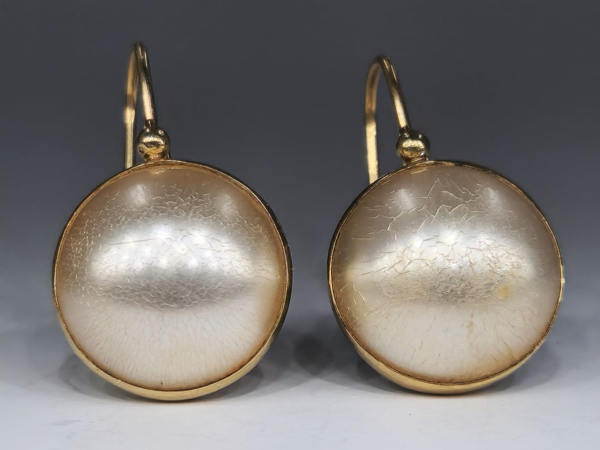 A pair of 14K gold earrings with blood pearls, unsigned but the purity of the gold is tested,