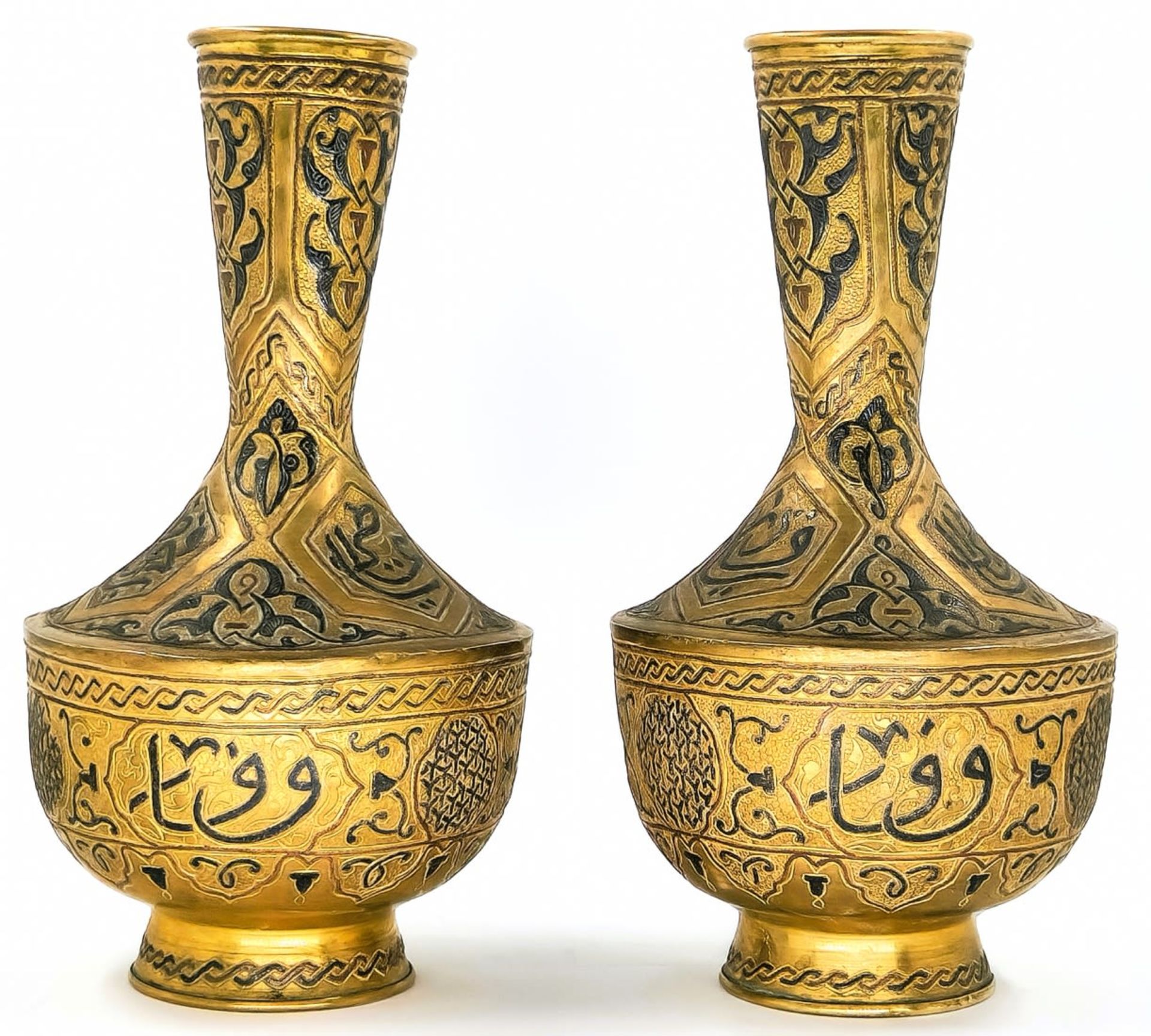 A pair of Islamic vases, decorated with 'Damascus work' (inlay of copper and silver in a brass),