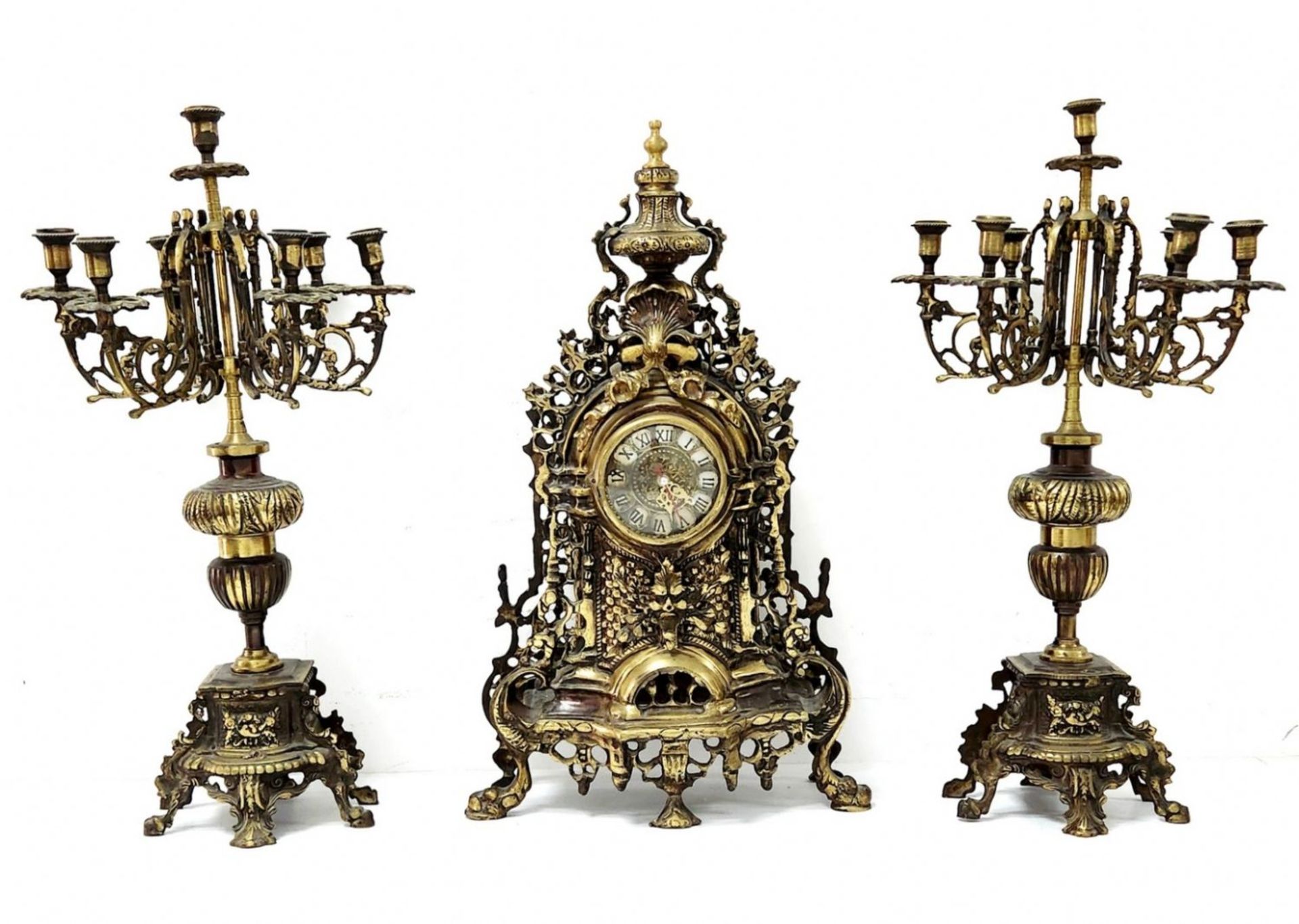 Antique Garniture, made of brass and includes a mantle clock and two candelabras, working