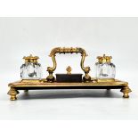 An antique double tabletop inkwell, brass and spelter, the ink wells themselves are made of glass,