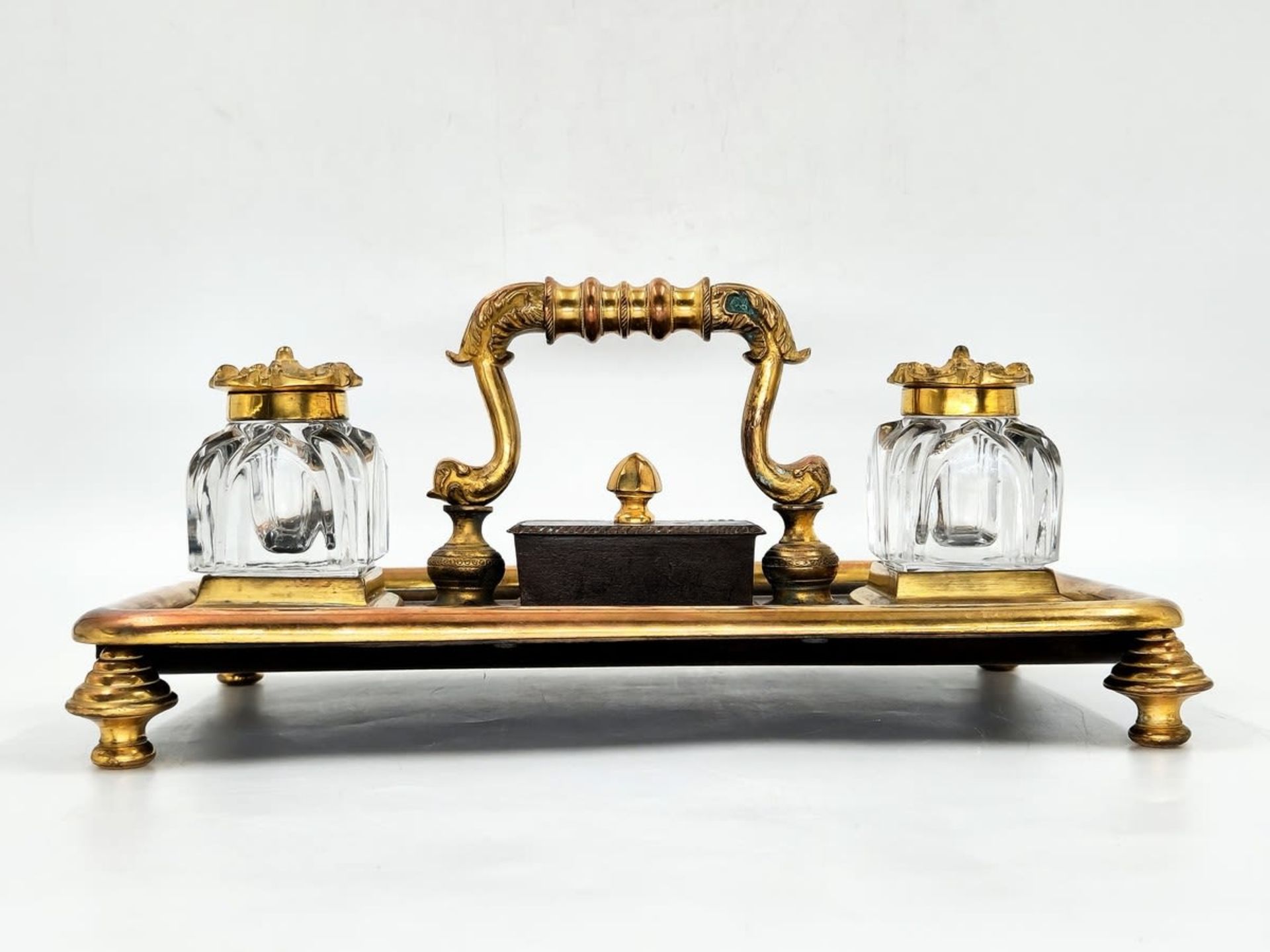An antique double tabletop inkwell, brass and spelter, the ink wells themselves are made of glass,