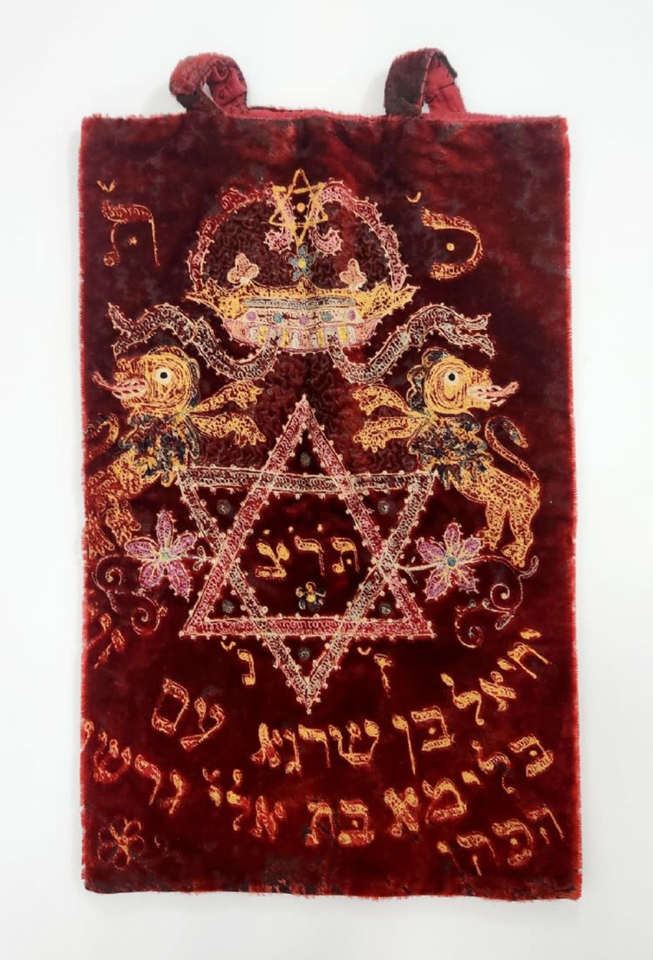 A Torah scroll coat, embroidered with cotton threads on red velvet, dating from 1929, the subject of