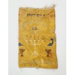 A Torah scroll coat, decorated with cotton threads on yellow silk, with illustrations of menorahs