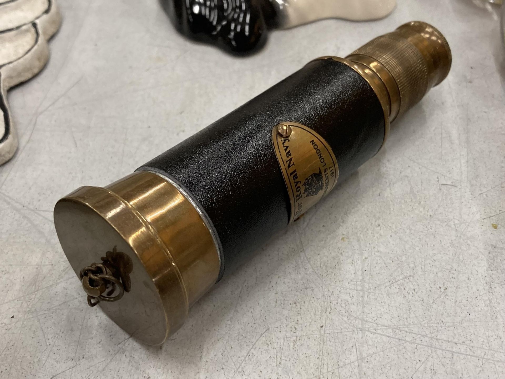 A BRASS AND LEATHER ROYAL NAVY TELESCOPE