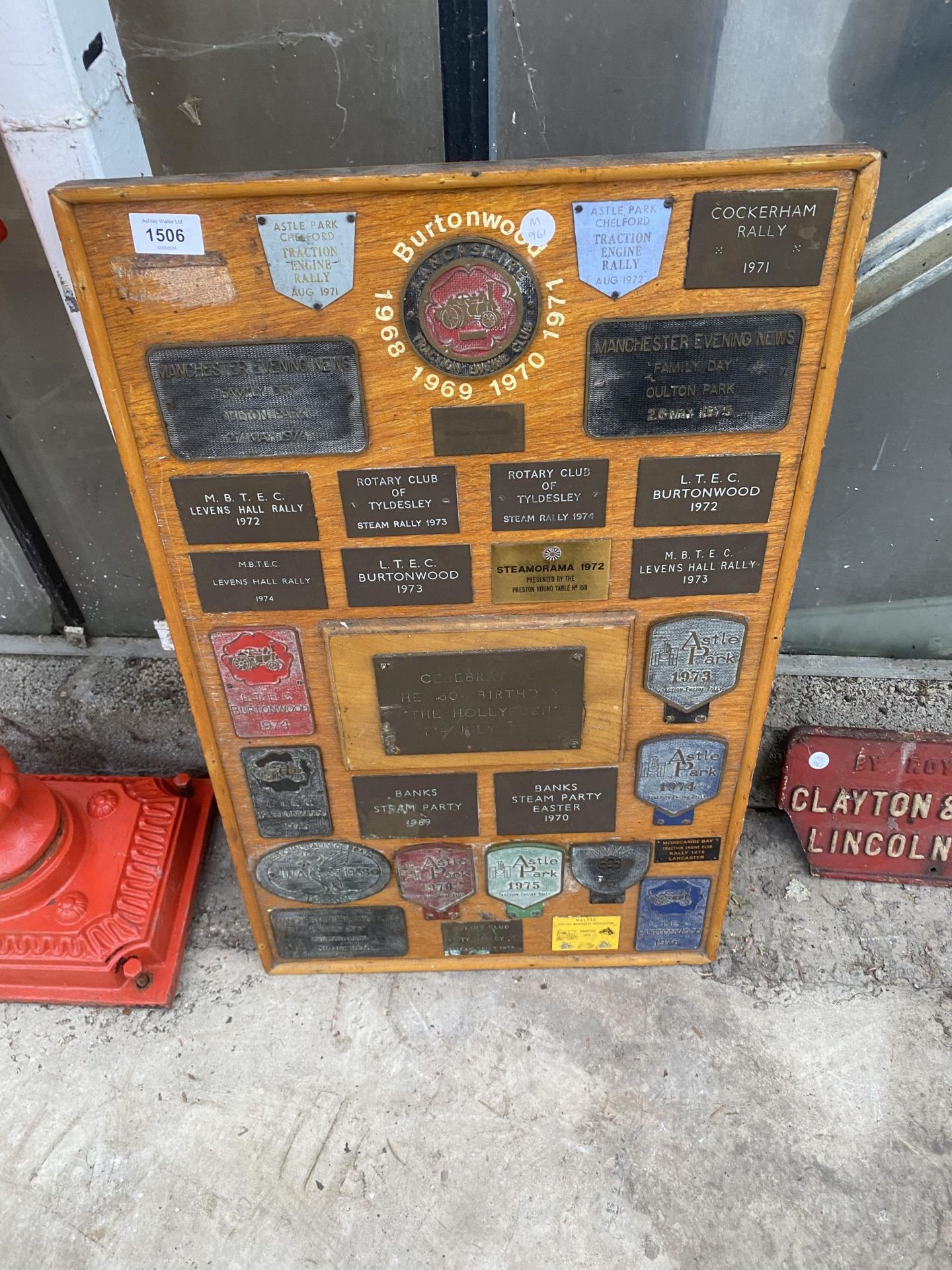 A WOODEN BOARD DISPLAYING A LARGE QUANTITY OF COMMEMERATIVE BRASS PLAQUES FROM VARIOUS STEAM RALLIES