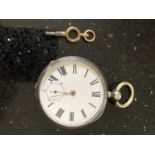 A HALLMARKED BIRMINGHAM SILVER POCKET WATCH WITH A WHITE ENAMEL DIAL AND ROMAN NUMERALS AND KEY (A/