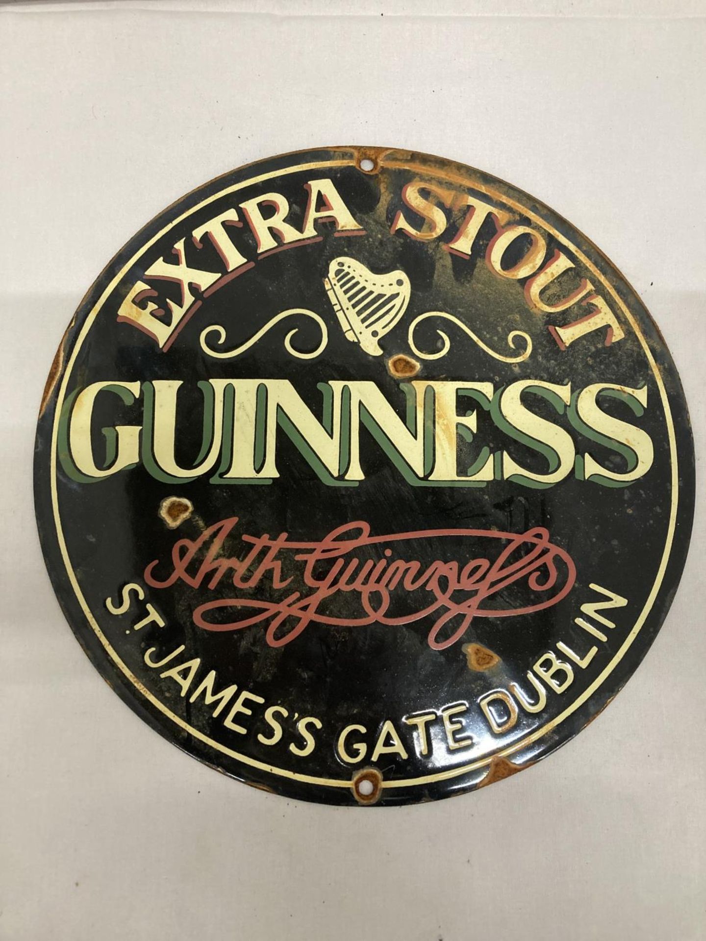 AN ENAMEL EXTRA STOUT GUINNESS CIRCULAR SIGN