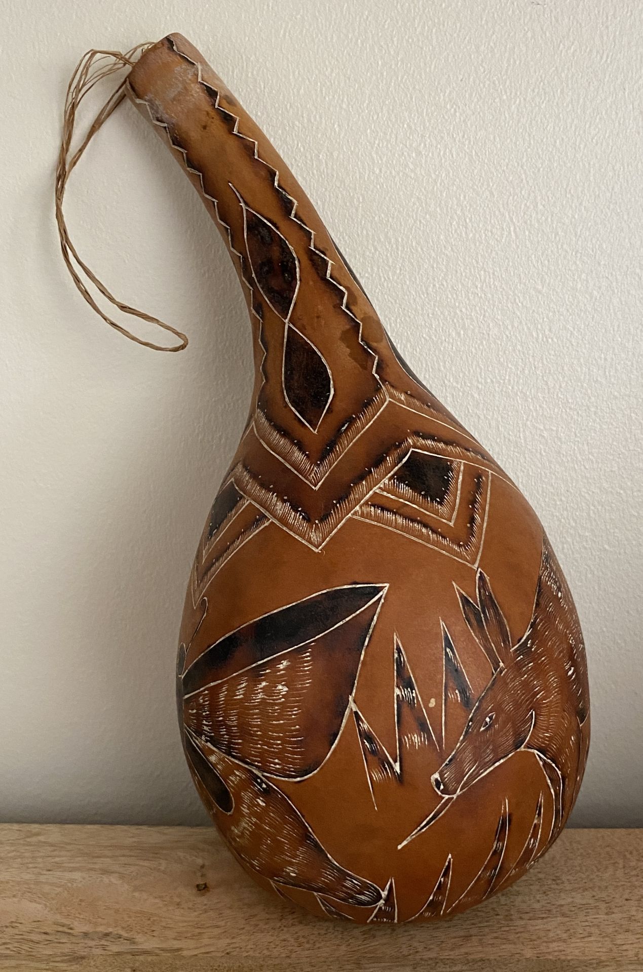 A VINTAGE AFRICAN TRIBAL GOURD WITH AARDVARK AND BUTTERFLY DESIGN, HEIGHT 29.5 CM