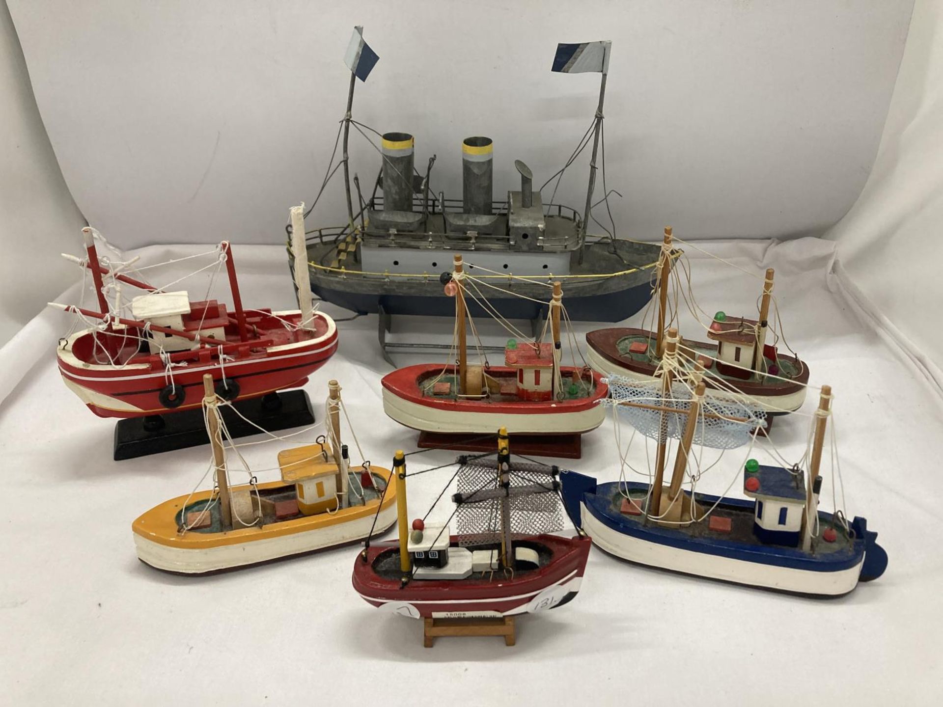 A COLLECTION OF SMALL WOODEN BOATS ON PLINTHS - 7 IN TOTAL