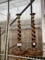 A PAIR OF OAK CARVED TWISTED CANDLESTICKS WITH BE=RASS CANDLE HOLDERS