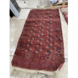 A VINTAGE RED PATTERNED FRINGED RUG