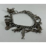 A VINTAGE SILVER CURB CHARM BRACELET WITH ASSORTED CHARMS, SOME SILVER, LENGTH 20 CM