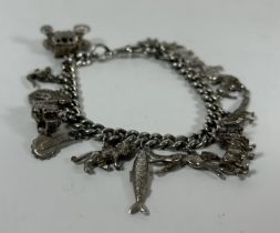 A VINTAGE SILVER CURB CHARM BRACELET WITH ASSORTED CHARMS, SOME SILVER, LENGTH 20 CM