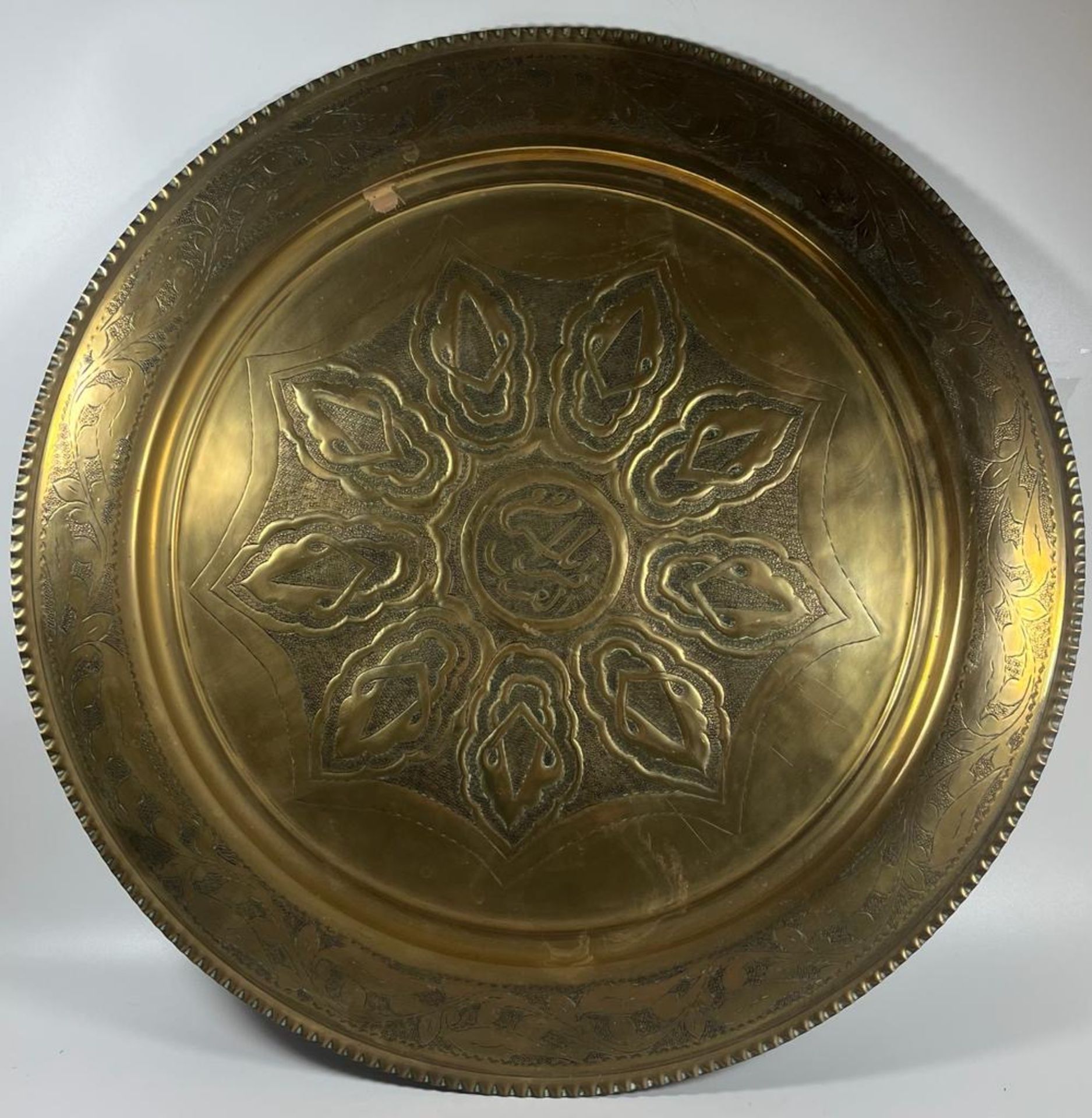 A LARGE ARTS & CRAFTS EARLY 20TH CENTURY BRASS CHARGER WITH STYLISED FLORAL DESIGN, DIAMETER 50 CM
