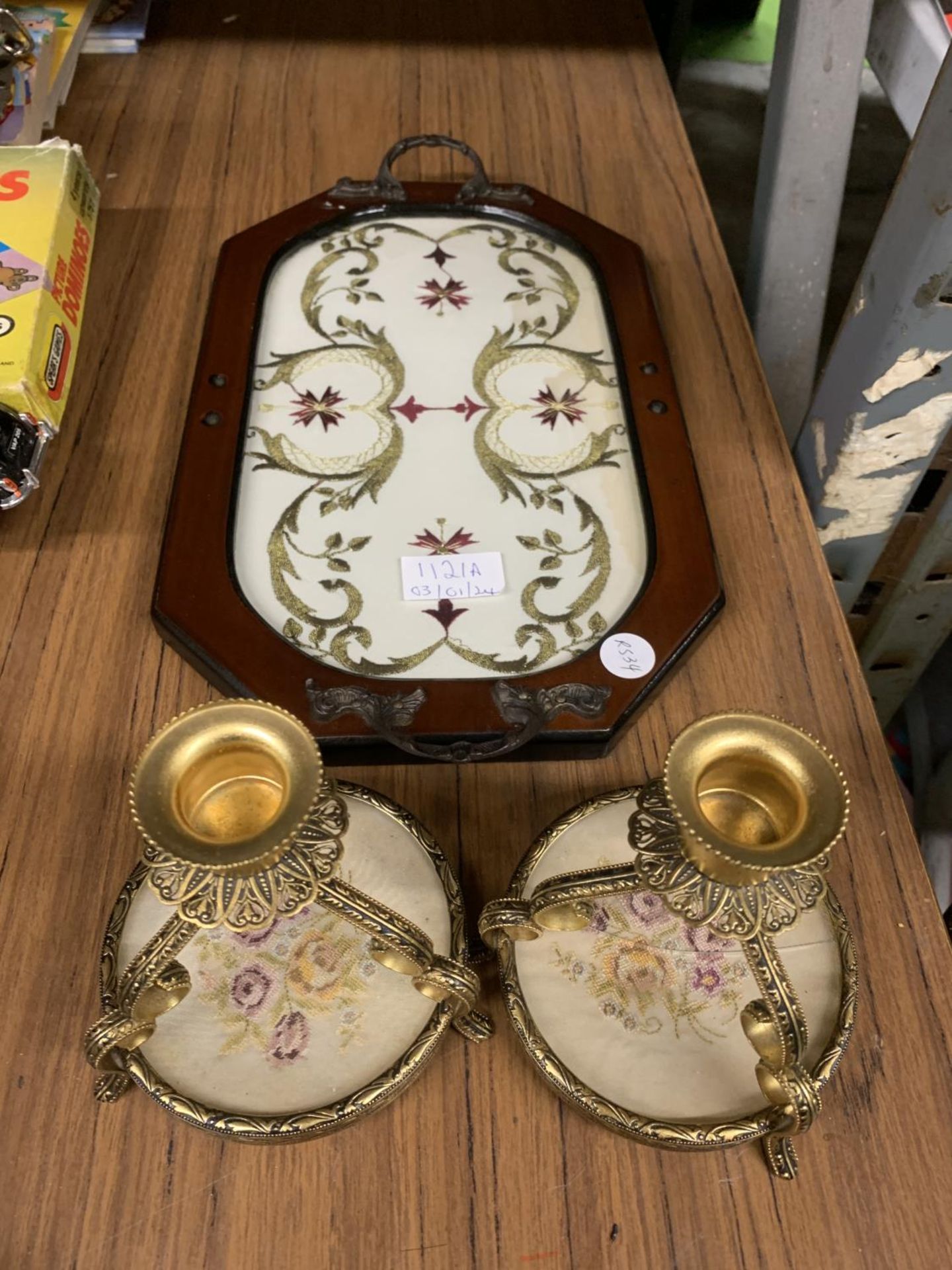 A VINTAGE WOODEN TRAY INLAID WITH SILK EMBROIDERY WITH TWO PETIT POINT CANDLESTICKS