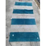 A SMALL BLUE AND BEIGE CARPET RUNNER