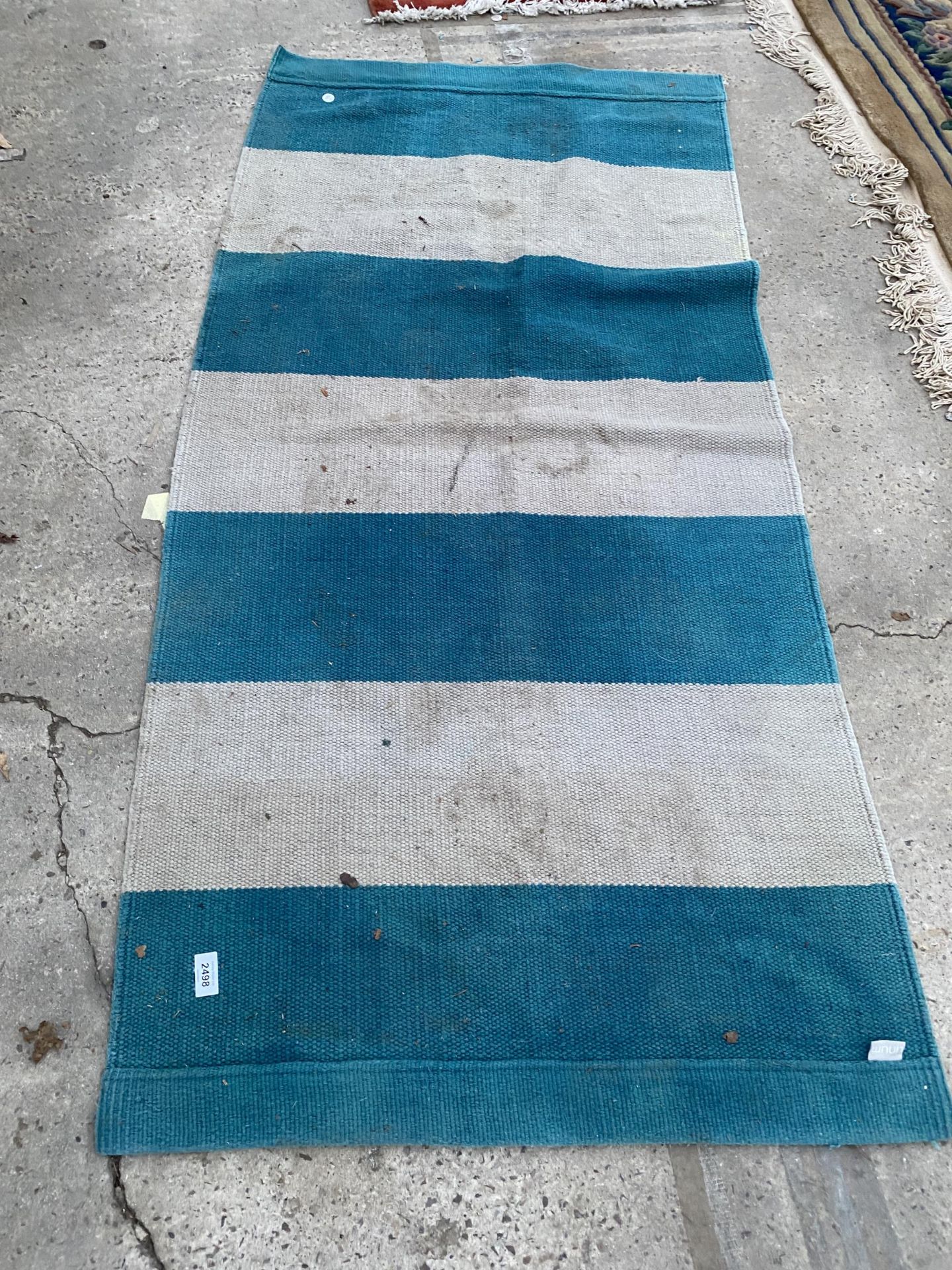 A SMALL BLUE AND BEIGE CARPET RUNNER