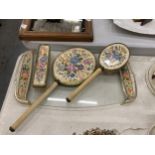 A VINTAGE PETIT-POINT BRUSH AND MIRROR SET ON A GLASS TRAY