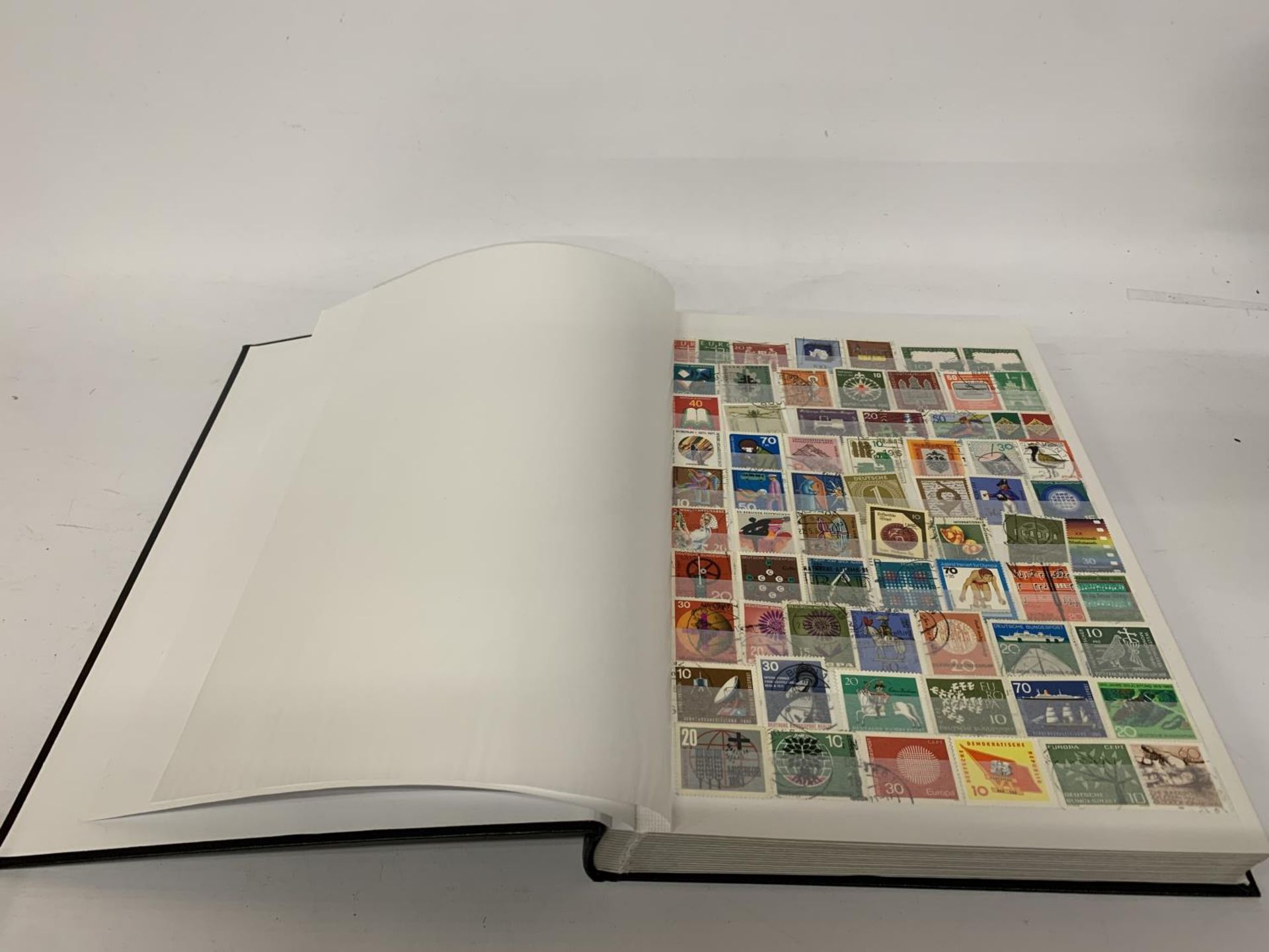 A STAMP ALBUM CONTAINING STAMPS FROM GERMANY AND DDR