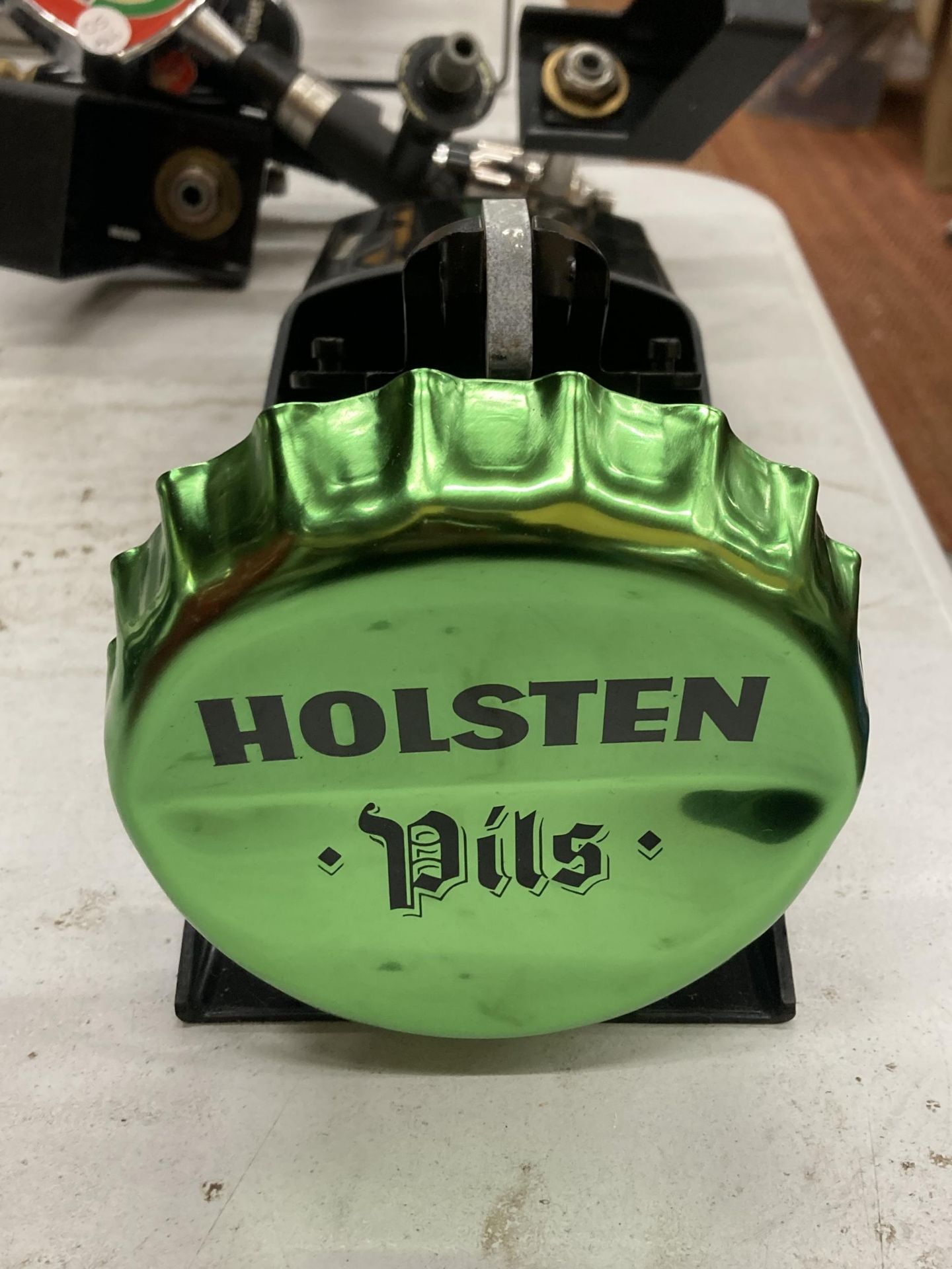 A NEW HOLSTEN PILS BOTTLE OPENER AND BOTTLE TOP HOLDER