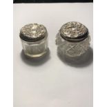 TWO GLASS JARS WITH ORNATE SILVER TOPS