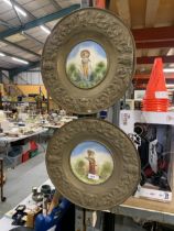 TWO VINTAGE BRASS WALL CHARGERS WITH CENTRAL FIGURE DESIGN PANELS