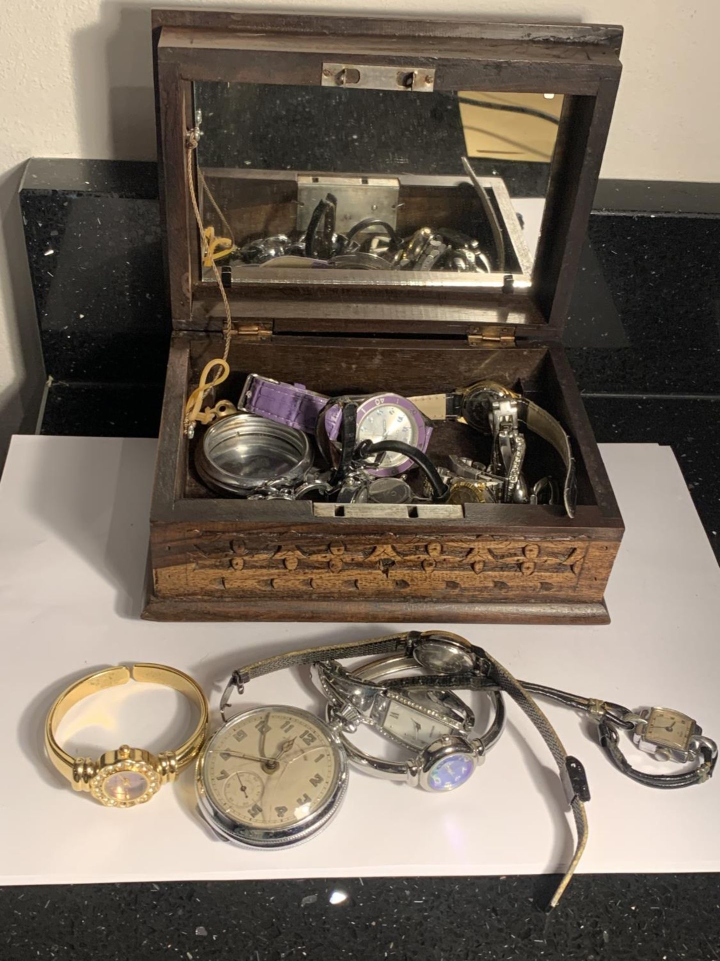 A CARVED WOODEN BOX WITH A QUANTITY OF WATCHES AND PARTS