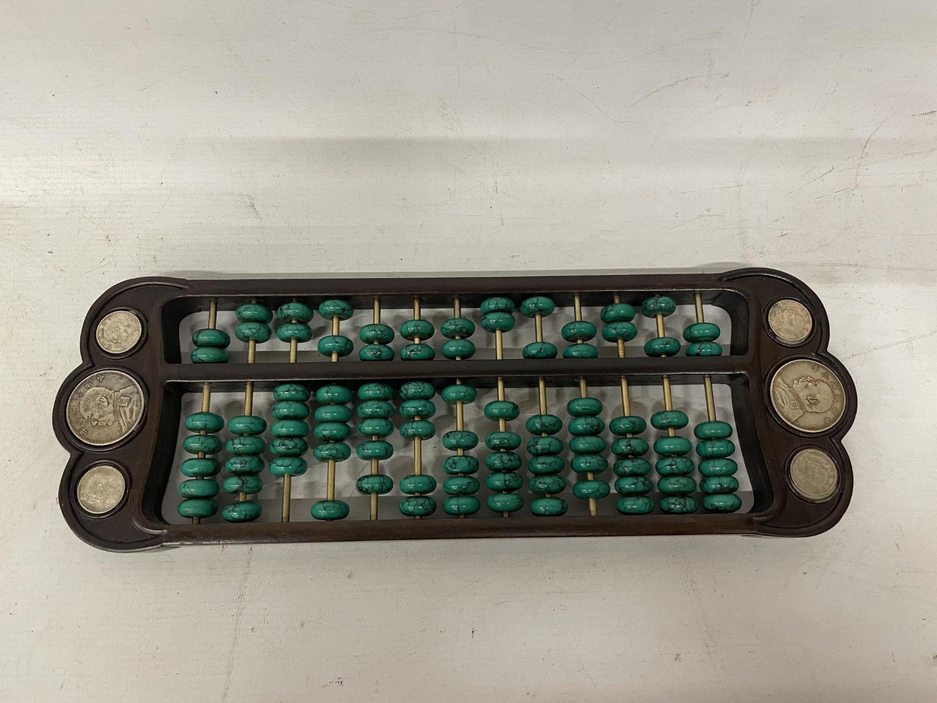 A CHINESE ABACUS WITH MALACHITE COUNTERS AND SILVER COINS