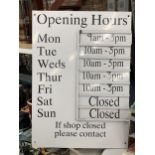 A METAL SHOP OPENING HOURS SIGN WITH INTERCHANGEABLE TIME SLIDES