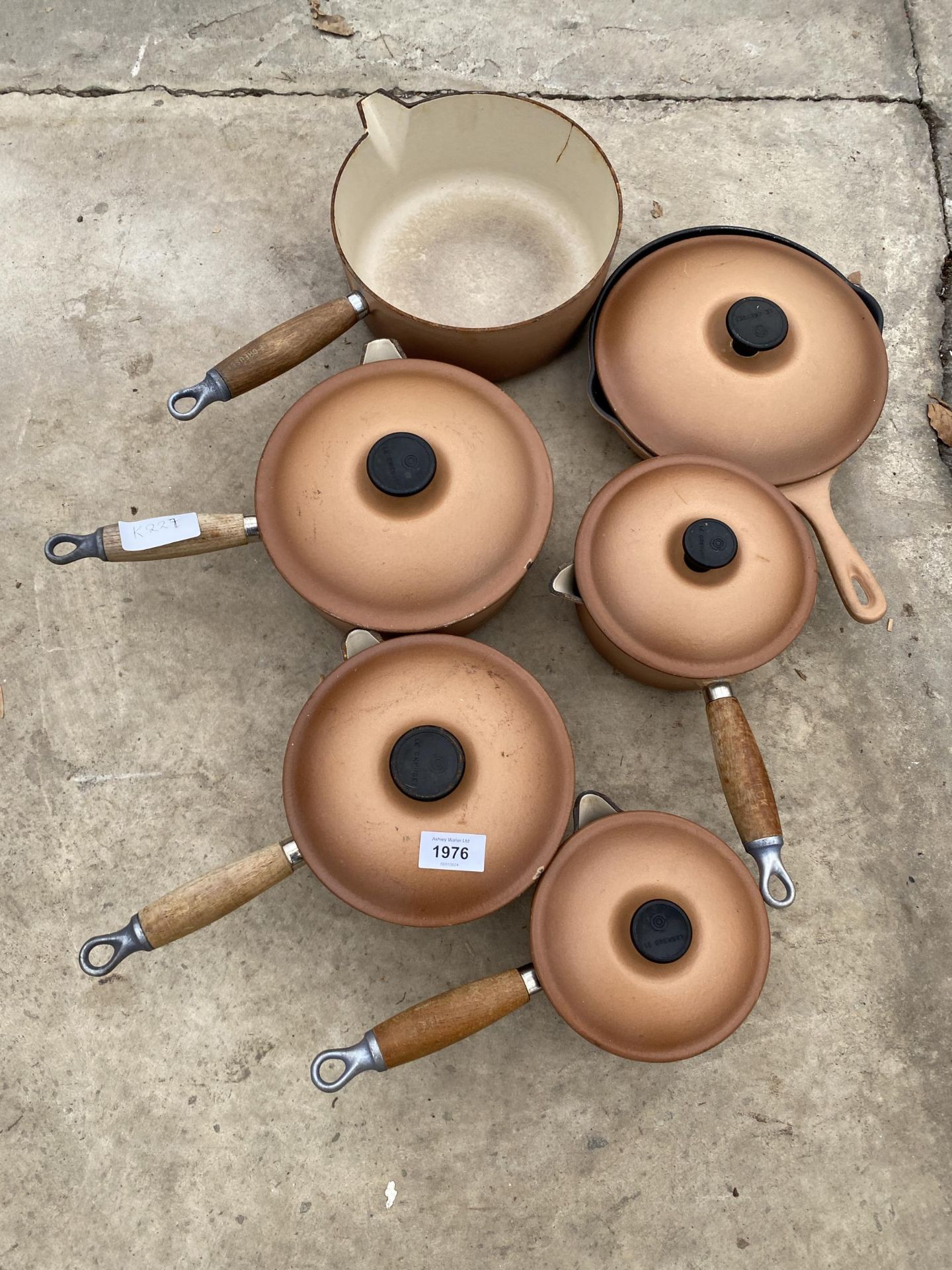 A SET OF SIX GRADUATED RETRO BROWN LE CREUSET PANS