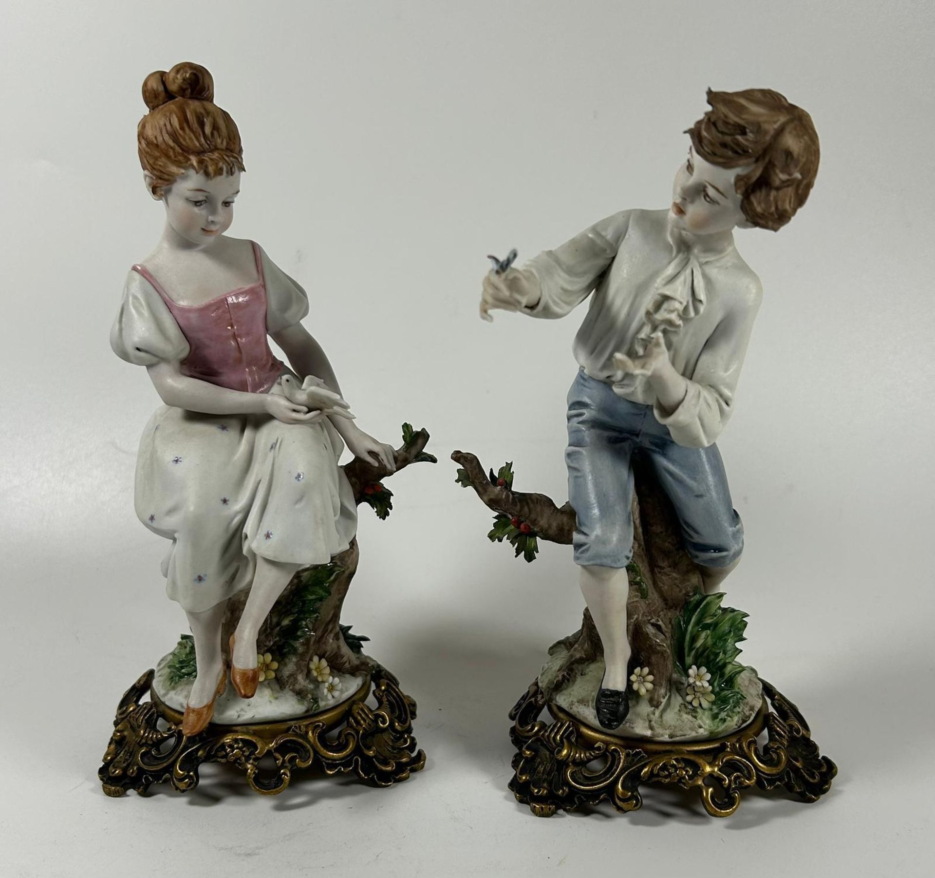 A PAIR OF CONTINENTAL PORCELAIN FIGURES OF A BOY AND GIRL ON GILT METAL BASES