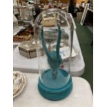 A TURQUOISE ANIMAL SKULL IN A GLASS DOME