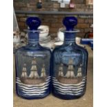 A PAIR OF VINTAGE BLUE GLASS BOTTLES WITH PAINTED SHIPS DESIGN