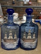 A PAIR OF VINTAGE BLUE GLASS BOTTLES WITH PAINTED SHIPS DESIGN